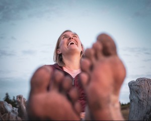 Erin Augustine, smiling with dirty toes in the foreground. Photo taken by Nick Irwin of Nick Irwin Images. Find him at www.nickirwinimages.com and @irwin.nick on Instagram
